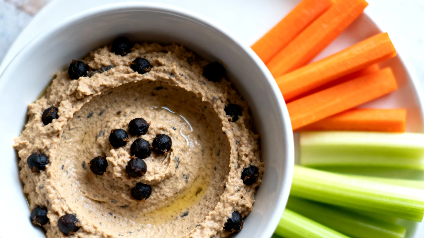 Hummus di ceci neri con bastoncini di sedano e carote"
