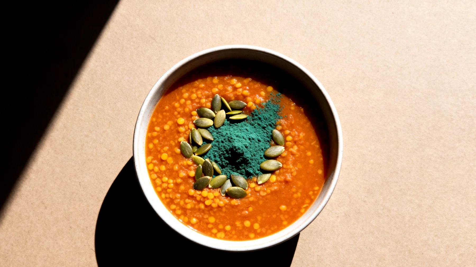 Zuppa di lenticchie rosse con semi di zucca e spirulina"